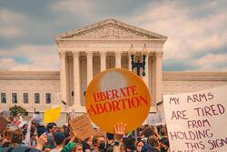  Protesters holding signs outside Supreme Court on Day Roe v Wade was overturned