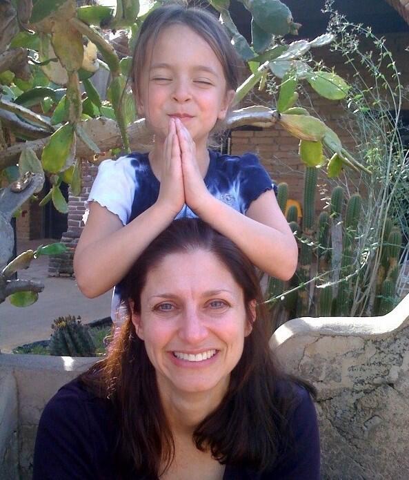 Woman with girl on her shoulders who had her hands in prayer position